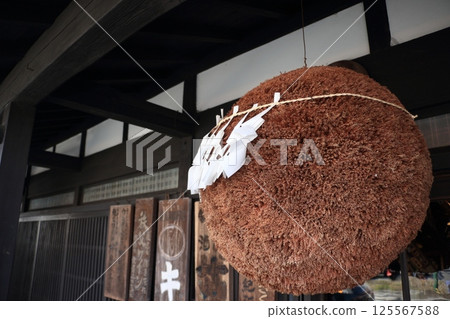 A large cedar ball hanging from the eaves of a sake brewery A large cedar ball hanging from the eaves of a sake brewery 125567588