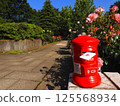 Red postbox in the rose garden 125568934