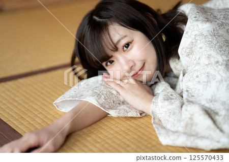 A young woman in a yukata resting in a tatami room 125570433