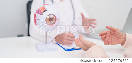 Elderly Patient consulting Doctor to Eye disease, Senior Medical Diagnosis. Anatomy Eye model for Cataract, Glaucoma, Age Related Macular Degeneration, Diabetic Retinopathy, Vitreous, health concept Elderly Patient consulting Doctor to Eye disease, Senior Medical Diagnosis. Anatomy Eye model for Cataract, Glaucoma, Age Related Macular Degeneration, Diabetic Retinopathy, Vitreous, health concept 125570711