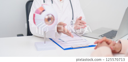 Elderly Patient consulting Doctor to Eye disease, Senior Medical Diagnosis. Anatomy Eye model for Cataract, Glaucoma, Age Related Macular Degeneration, Diabetic Retinopathy, Vitreous, health concept 125570713