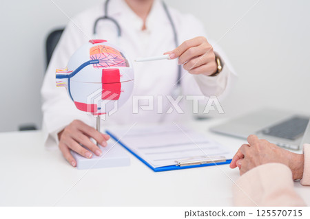 Elderly Patient consulting Doctor to Eye disease, Senior Medical Diagnosis. Anatomy Eye model for Cataract, Glaucoma, Age Related Macular Degeneration, Diabetic Retinopathy, Vitreous, health concept Elderly Patient consulting Doctor to Eye disease, Senior Medical Diagnosis. Anatomy Eye model for Cataract, Glaucoma, Age Related Macular Degeneration, Diabetic Retinopathy, Vitreous, health concept 125570715
