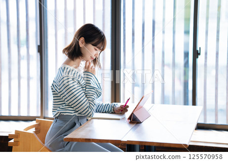 Young woman studying using a tablet 125570958