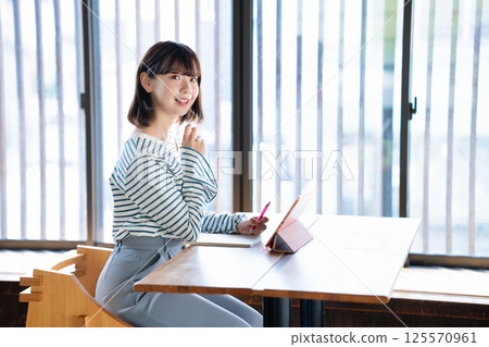Young woman studying using a tablet 125570961