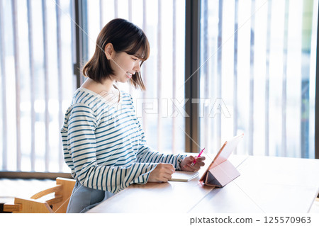 使用平板電腦學習的年輕女性 使用平板電腦學習的年輕女性 125570963