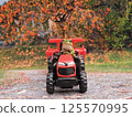 Riding a red tractor 125570995