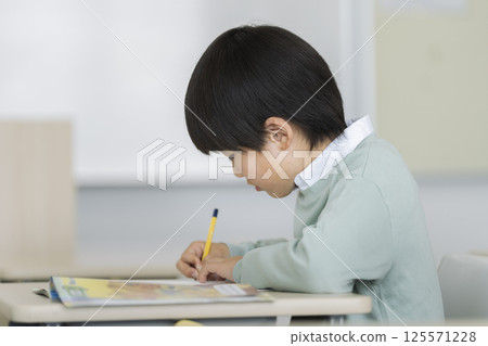 Profile of a fourth grade boy studying 125571228