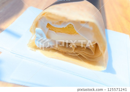 Cross section of a crepe filled with cheesecake and whipped cream 125571241
