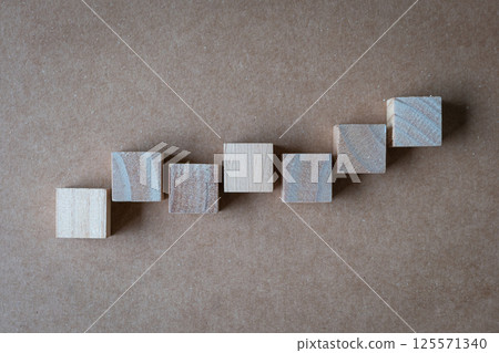 Seven blank square wooden blocks in uneven steps up direction on plain background. 125571340