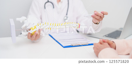 Elderly Patient consulting Doctor with Spine anatomy for Spinal Cord Disorder and disease, Back pain, Lumbar, Sacral pelvis, Cervical neck, Thoracic, Coccyx, Orthopedist, chiropractic, Office Syndrome Elderly Patient consulting Doctor with Spine anatomy for Spinal Cord Disorder and disease, Back pain, Lumbar, Sacral pelvis, Cervical neck, Thoracic, Coccyx, Orthopedist, chiropractic, Office Syndrome 125571820