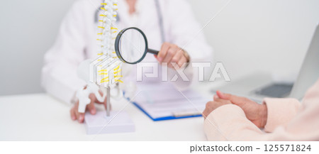 Elderly Patient consulting Doctor with Spine anatomy for Spinal Cord Disorder and disease, Back pain, Lumbar, Sacral pelvis, Cervical neck, Thoracic, Coccyx, Orthopedist, chiropractic, Office Syndrome 125571824