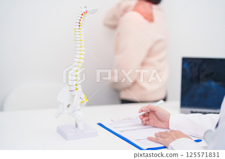 Elderly Patient consulting Doctor with Spine anatomy for Spinal Cord Disorder and disease, Back pain, Lumbar, Sacral pelvis, Cervical neck, Thoracic, Coccyx, Orthopedist, chiropractic, Office Syndrome 125571831