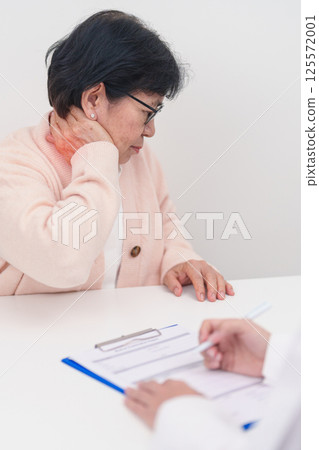 Elderly Woman having Shoulder and Neck and consulting doctor in hospital. Muscle painful due to Myofascial pain syndrome and Fibromyalgia, rheumatism, Scapular pain, Cervical Spine. ergonomic concept 125572001
