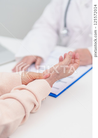 Elderly Patient Woman wrist pain and Consulting doctor. muscle ache from Carpal Tunnel Syndrome, De Quervain s tenosynovitis, rheumatoid, arthritis, gout, Parkinson disease and ergonomic healthcare 125572014