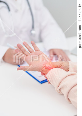 Elderly Patient Woman wrist pain and Consulting doctor. muscle ache from Carpal Tunnel Syndrome, De Quervain s tenosynovitis, rheumatoid, arthritis, gout, Parkinson disease and ergonomic healthcare 125572016