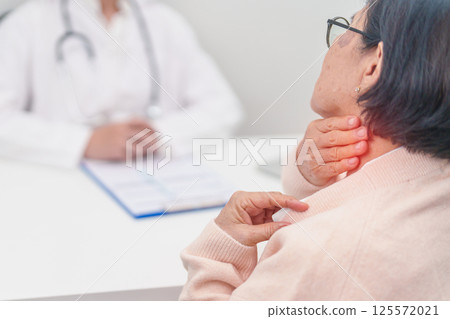 Elderly Woman having Shoulder and Neck and consulting doctor in hospital. Muscle painful due to Myofascial pain syndrome and Fibromyalgia, rheumatism, Scapular pain, Cervical Spine. ergonomic concept 125572021