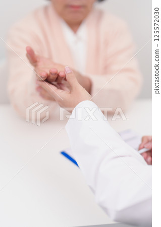 Elderly Patient Woman wrist pain and Consulting doctor. muscle ache from Carpal Tunnel Syndrome, De Quervain s tenosynovitis, rheumatoid, arthritis, gout, Parkinson disease and ergonomic healthcare 125572030