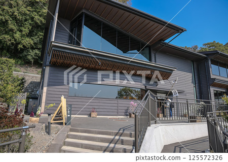 March 23 2025 Modern Black Building Exterior with Visitor Standing Outside 125572326