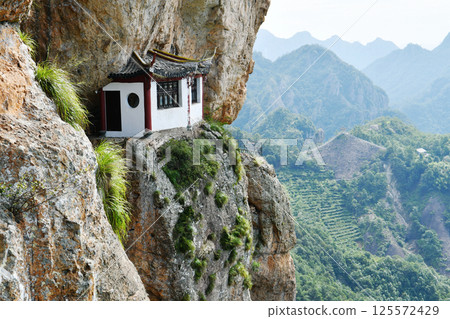 a traditional Chinese style house on the edge of a cliff in the mountains, Zhejiang Province, China 125572429