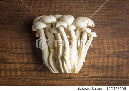 Raw white shimeji mushrooms on wooden table. Top view. 125572506