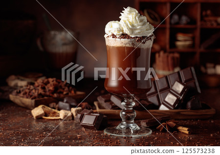 Hot chocolate with whipped cream in a glass mug. 125573238