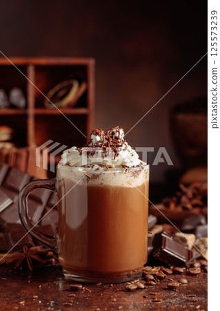 Chocolate drink topped with whipped cream and sprinkled with chocolate chips. 125573239