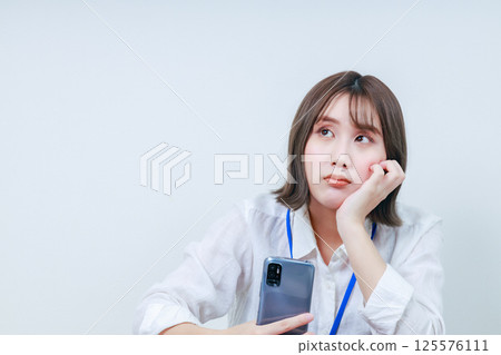 A young woman thinking with a cane on her cheek 125576111