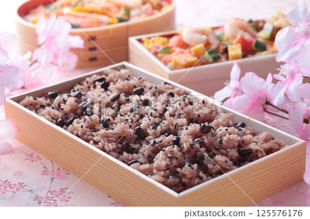 在日本的慶祝活動中，人們會吃紅米飯，照片中紅米飯的粉紅色背景上點綴著櫻花。 125576176