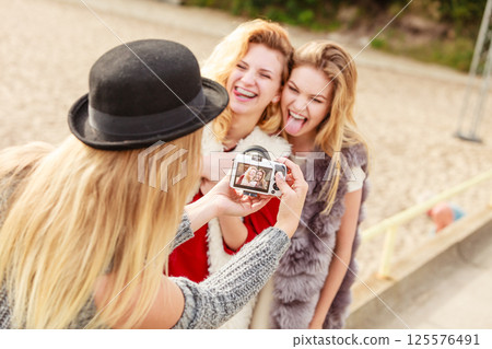 Fun woman taking pictures of females 125576491
