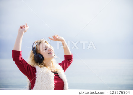 Happy woman wearing headphones outdoor Happy woman wearing headphones outdoor 125576504