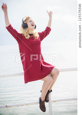 Happy woman wearing headphones outdoor Happy woman wearing headphones outdoor 125576506