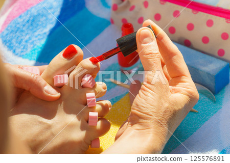 Woman pedicure with red nail polish 125576891