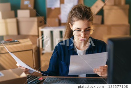 Woman working in a warehouse. Woman working in a warehouse. 125577108