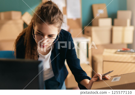 Woman working in a warehouse. Woman working in a warehouse. 125577110