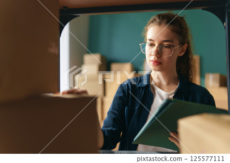 Woman working in a warehouse. Woman working in a warehouse. 125577111