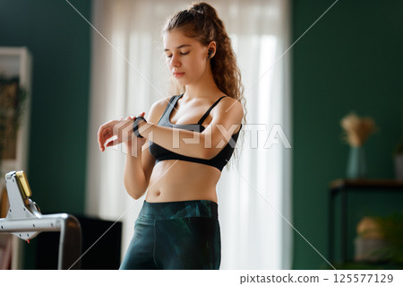 Young woman running on a treadmill indoors Young woman running on a treadmill indoors 125577129