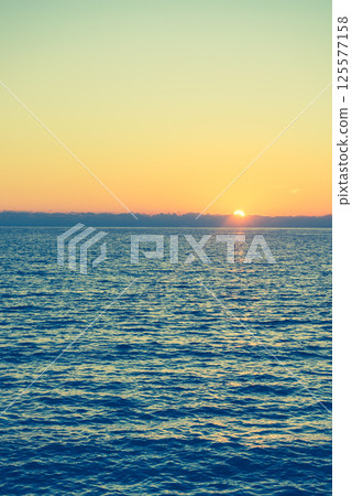 Sunset or sunrise over sea surface Sunset or sunrise over sea surface 125577158