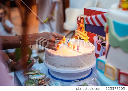 Lighting Birthday Cake Candles at a Party Celebration 125577205