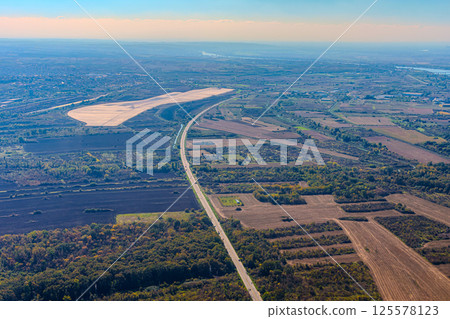 Aerial view of valley with farm fields, pond and Danube river. High quality photo 125578123