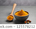 Aromatic turmeric powder and raw roots on grey table, closeup 125578212