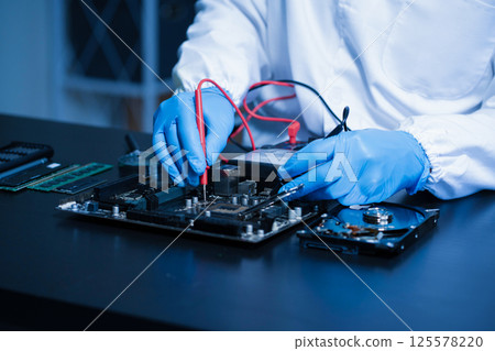 Hands repairing electronic devices. Electronic technician. Hands repairing electronic devices. Electronic technician. 125578220