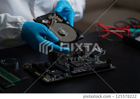 Hands repairing electronic devices. Electronic technician. Hands repairing electronic devices. Electronic technician. 125578222
