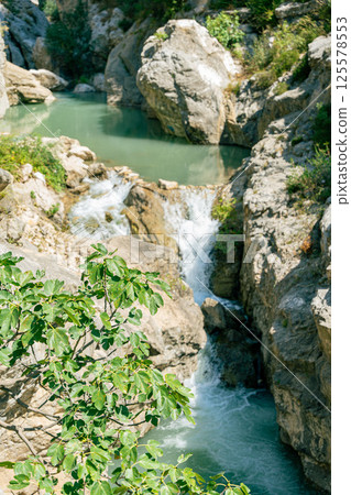 Small waterfall of a stream in sunny nature 125578553