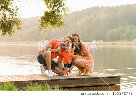 Family Sitting On Wooden Dock 125578771
