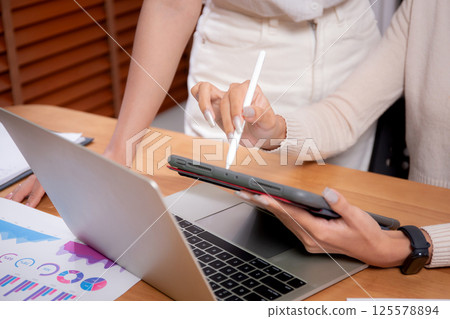 Closeup hand of two young asian businesswoman planning and strategy about marketing and financial. 125578894