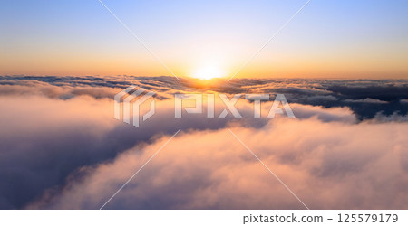 Aerial Epic View Above Clouds with Beautiful Sunset Light. Dramatic Cloudy Sky With Golden Light. Aerial Epic View Above Clouds with Beautiful Sunset Light. Dramatic Cloudy Sky With Golden Light. 125579179