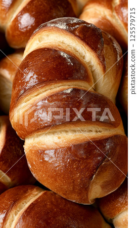 Close-up of freshly baked bread pastries in traditional bakery. concept of artisanal baking, homemade recipes, rustic bakery delights.. Vertical 125579715