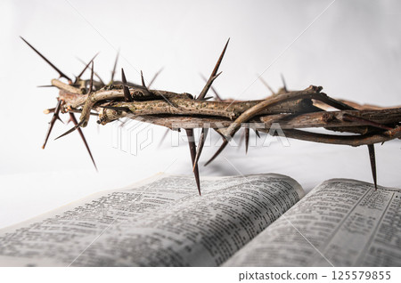 Crown of thorns and Bible a white background, creating a symbolic easter image of suffering, sacrifice, and remembrance Copy space for text good friday Crown of thorns and Bible a white background, creating a symbolic easter image of suffering, sacrifice, and remembrance Copy space for text good friday 125579855