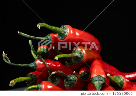 Close-up of red chili peppers with green stems Close-up of red chili peppers with green stems 125580065