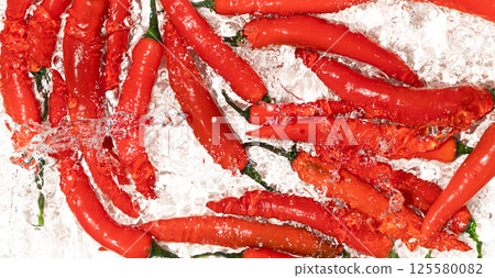 Vibrant Chili Peppers Washed in Water Close-Up 125580082